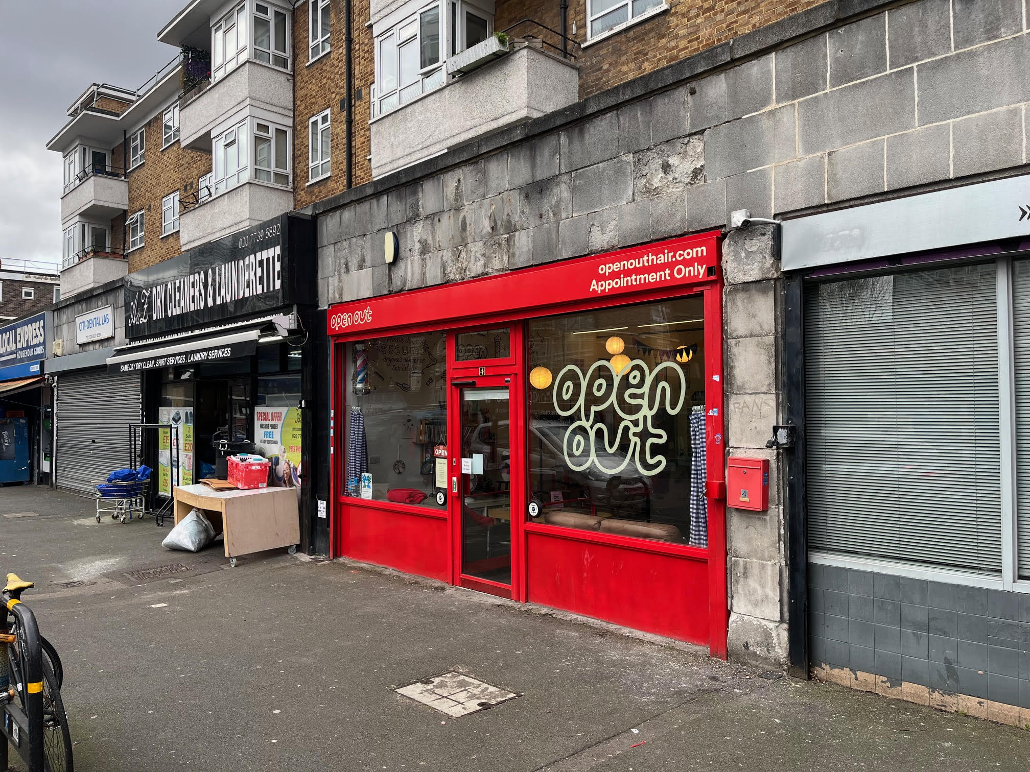 A photo of the shop front of Open Out showing the neighbouring shops also.